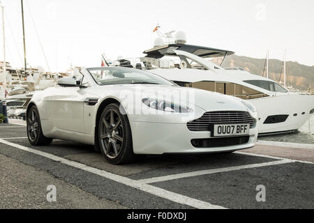 Aston Martin Vantage V8 auto sportiva, parcheggiato di fronte yacht di lusso, Puerto Banus a Marbella, Andalusia, Spagna. Foto Stock