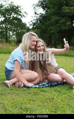 Due ragazze adolescenti all'aperto prendendo un selfie Foto Stock