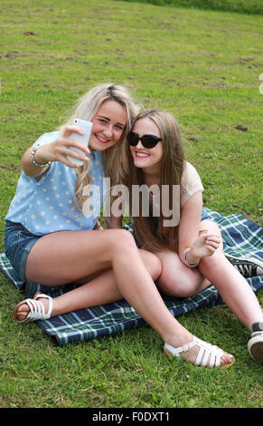 Due ragazze adolescenti all'aperto prendendo un selfie Foto Stock