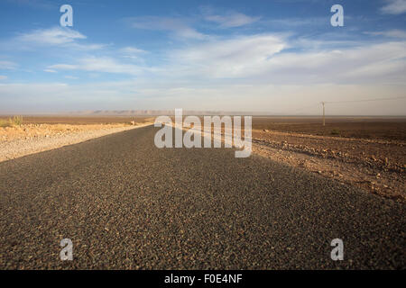 Panorama di strada diritta contro un cielo azzurro nel sud del Marocco Foto Stock