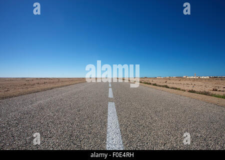 Panorama di strada diritta contro un cielo azzurro nel sud del Marocco Foto Stock