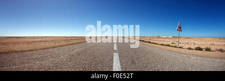 Panorama di strada diritta contro un cielo azzurro nel sud del Marocco Foto Stock