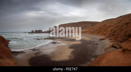 Vuoto e selvaggia spiaggia con scogliere sulla costa Legzira nel sud del Marocco Foto Stock