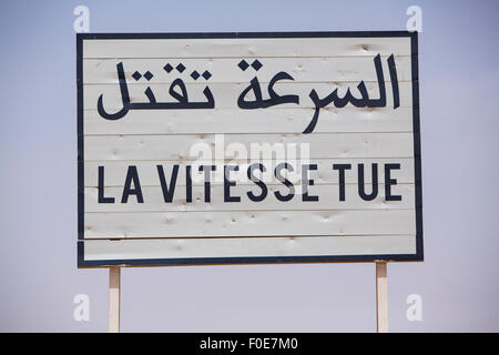 Velocità del traffico uccide cartello stradale scritto in francese e arabo su sfondo blu Foto Stock