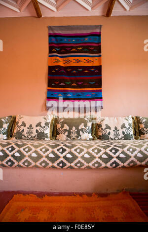 Tessuti colorati e arredi tradizionali in classico interno marocchino. Foto Stock