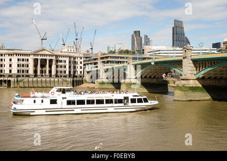 Una crociera turistica viaggia sotto il ponte Southwark a Londra. Foto Stock