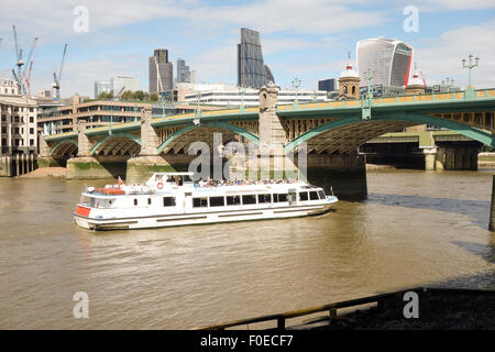 Una crociera turistica viaggia sotto il ponte Southwark a Londra. Foto Stock