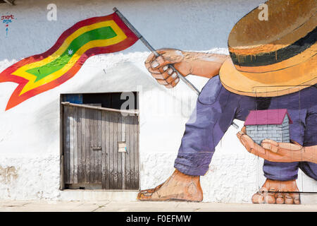 L'uomo con il cappello e la casa e un colombiano bandiera nelle sue mani, Massive vintage graffiti dipinta su un muro di Cartagena Foto Stock