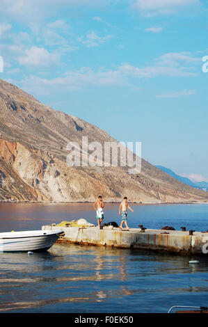 Due ragazzi su un molo nel borgo marinaro di Loutro nel sud-ovest di Creta, Grecia Foto Stock