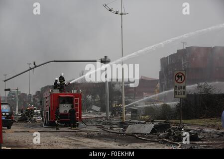 Tianjin, Cina. 14 Ago, 2015. I vigili del fuoco di mettere fuori fuoco in un contenitore in corrispondenza del sito dell'esplosione di Tianjin, Cina del nord, 14 agosto 2015. Un'esplosione, che si è verificato Mercoledì notte in un magazzino di Tianjin, ha lasciato almeno 50 morti e 701 altri feriti. Credito: Shen Bohan/Xinhua/Alamy Live News Foto Stock