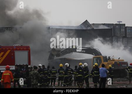 Tianjin, Cina. 14 Ago, 2015. I vigili del fuoco di mettere fuori fuoco in un contenitore in corrispondenza del sito dell'esplosione di Tianjin, Cina del nord, 14 agosto 2015. Un'esplosione, che si è verificato Mercoledì notte in un magazzino di Tianjin, ha lasciato almeno 50 morti e 701 altri feriti. Credito: Shen Bohan/Xinhua/Alamy Live News Foto Stock