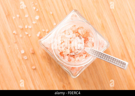 Close up di Sale Himalayano nel vasetto di vetro su un tavolo di legno. Il cibo ancora in vita. Foto Stock