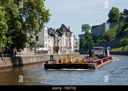 Una chiatta sul fiume Sambre, pesantemente carico di ghiaia, passa sotto la fortezza della Cittadella nella città di Namur, Belgio Foto Stock