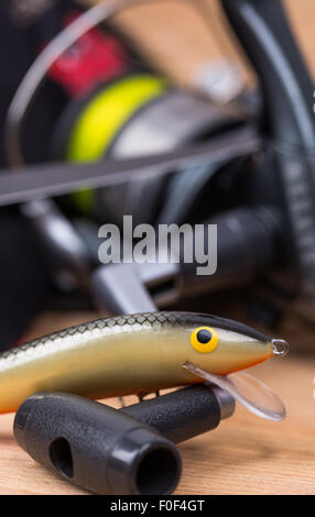 Closeup esche da pesca wobbler con aspo su sfondo di legno con il fuoco selettivo Foto Stock