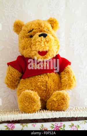 Winnie the Pooh bear morbido peluche seduto sul cesto di vimini Foto Stock