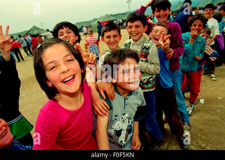 Profughi kosovari a camp Strankovic Macedonia 1999 .. felici i bambini e giocare mentre si fermò in code di cibo Foto Stock