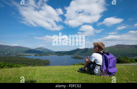 Un ragazzo si ferma a prendere in considerazione di Derwentwater nel distretto del lago da Catbells cadde vicino a Keswick, Cumbria, Regno Unito Foto Stock