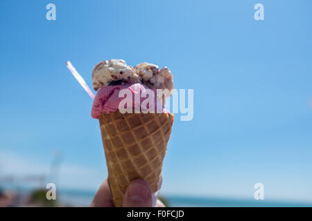 Cono gelato contro un luminoso chiaro Cielo di estate blu Foto Stock