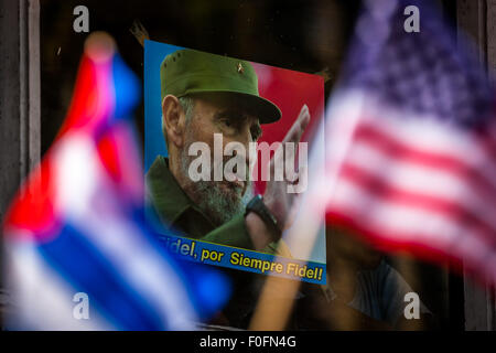 L'Avana, Cuba. 14 Ago, 2015. Persone wave bandiere nazionali di Cuba e gli Stati Uniti di fronte ad un poster di Fidel Castro che dice "Fidel forever' durante l'alzabandiera cerimonia presso l ambasciata degli Stati Uniti all Avana, Cuba, 14 agosto 2015. Stati Uniti Il segretario di Stato John Kerry presieduto qui il venerdì la cerimonia formale di innalzare la bandiera americana nel recentemente riaperto l'ambasciata degli Stati Uniti a Cuba, dopo 54 anni di ostilità tra i due paesi vicini. Credito: Liu Bin/Xinhua/Alamy Live News Foto Stock