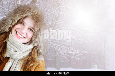 Bella giovane donna in pelliccia del cofano il cappotto esterno sulla soleggiata giornata nevosa con spazio di copia Foto Stock