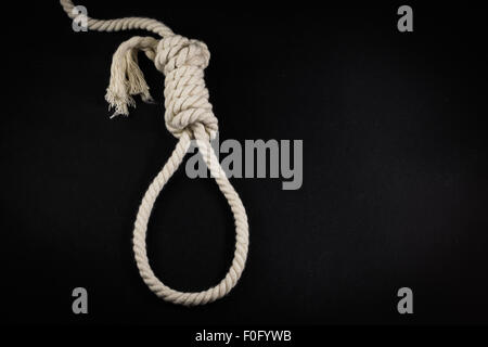 Svuotare l'impiccato il cappio realizzato dalla corda bianca insieme contro un nero di sfondo per studio Foto Stock