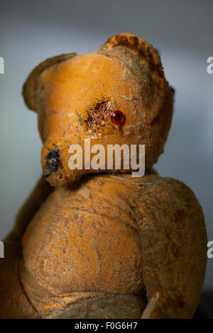 Un vecchio usurato orsacchiotto con occhio danneggiato. Foto Stock