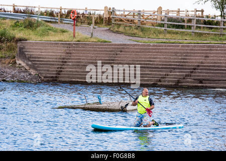 Un uomo pala dando lezioni di imbarco a un gruppo di persone a Chasewater Country Park lichfield, Staffordshire, Regno Unito Foto Stock