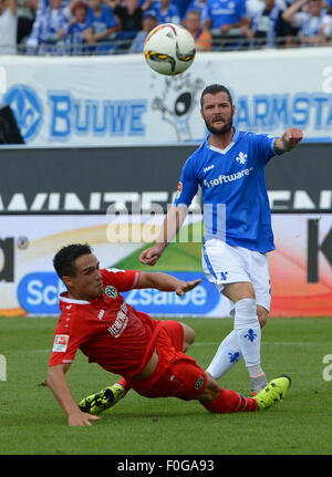 Darmstadt, Germania. Il 15 agosto, 2015. Darmstadt Marcel Heller punteggi 1-0 obiettivo, con Hannover Manuel Schmiedebach alla sua sinistra, durante la Bundesliga tedesca partita di calcio tra SV Darmstadt 98 e Hannover 96 a Merck-Stadion a Darmstadt, Germania, 15 agosto 2015. Foto: ROLAND HOLSCHNEIDER/dpa (EMBARGO CONDIZIONI - ATTENZIONE: grazie alle linee guida di accreditamento, il DFL consente solo la pubblicazione e utilizzazione di fino a 15 immagini per corrispondenza su internet e nei contenuti multimediali in linea durante la partita.)/dpa/Alamy Live News Foto Stock