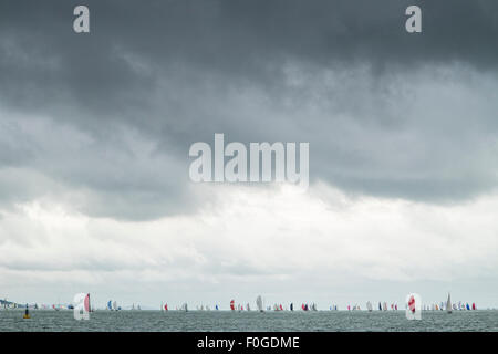 Scene da Cowes Week sull'Isola di Wight in Inghilterra - Yacht Race al di sotto di un colore molto scuro, plumbeo, nuvoloso, cielo tempestoso Foto Stock