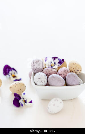 Pasqua mini uova e fiori di primavera in un cuore ciotola sagomata Foto Stock