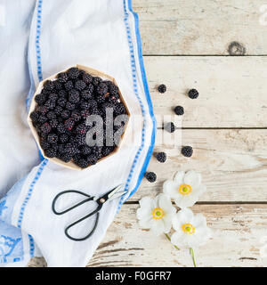 More in un cestino sul tavolo con il canovaccio e anemoni Foto Stock