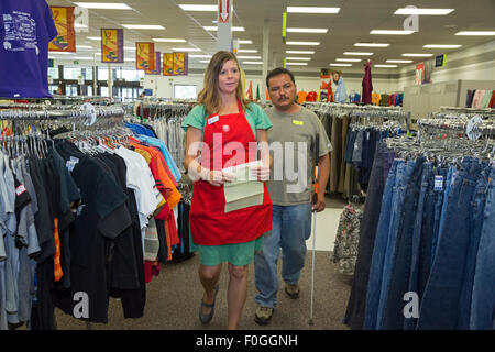 Salt Lake City, Utah - un volontario aiuta un uomo cieco trovare scarpe a le industrie Deseret' parsimonia store. Foto Stock
