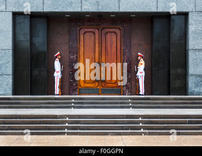 Bianco uniforme della guardia d'onore si erge guardare in ingresso al Mausoleo di Ho Chi Minh ad Hanoi, Vietnam Foto Stock