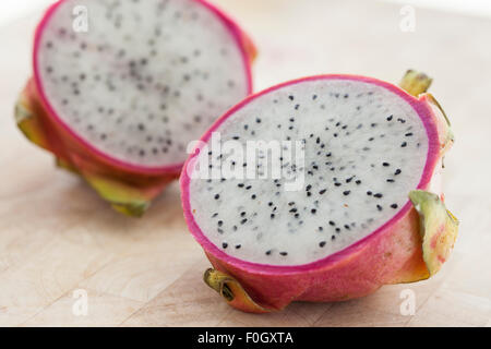 Un drago a fette frutta su una superficie in legno fotografato con finestra luce. Foto Stock