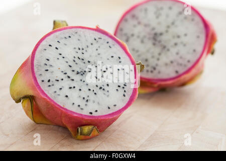 Un drago a fette frutta su una superficie in legno fotografato con finestra luce. Foto Stock