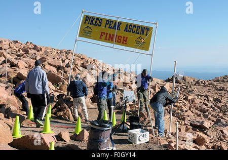 Manitou Springs, Colorado, Stati Uniti d'America. Il 15 agosto, 2015. Gara lavoratori battaglia il vertice vento per impostare il banner di finitura prima della sessantesima edizione del Pikes Peak ascesa. Durante la fase di ascesa, coperchio guide 13.3 miglia e guadagnare più di 7815 piedi (2382m) dal momento in cui essi raggiungono il 14,115ft (4302m) vertice. Il secondo giorno del weekend di gara, 800 marathoners renderanno il viaggio di andata e ritorno e il coperchio 26.6 miglia di altitudine elevata e terreno molto difficile in Pike National Forest, Manitou Springs, CO. © csm/Alamy Live News Foto Stock