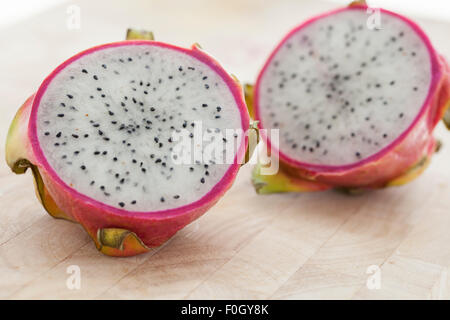 Un drago a fette frutta su una superficie in legno fotografato con finestra luce. Foto Stock