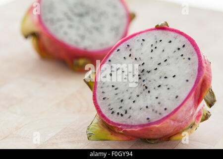 Un drago a fette frutta su una superficie in legno fotografato con finestra luce. Foto Stock