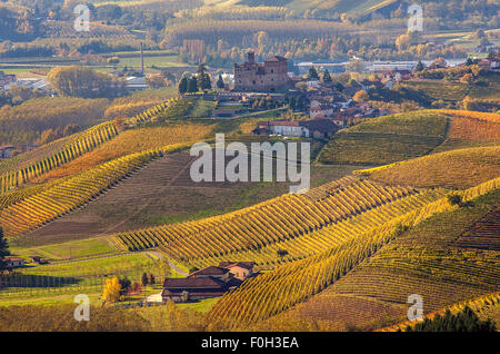 Piccola città sulla collina e colorate vigneti di Piemonte, Italia settentrionale. Foto Stock