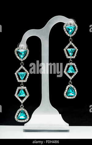 Orecchini con pietre blu sul nero Foto Stock