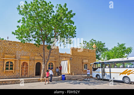 Rajasthani, architettura indiana, una casa con alberi, con un autobus turistico parcheggiato di fronte, i turisti a piedi da spazio di copia Foto Stock