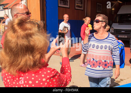 Staithes, UK. Il 15 agosto, 2015. La vincente duck è baciata dal suo proprietario. Il RNLI ( Royal National scialuppa di salvataggio Institute) tiene annualmente un weekend per la raccolta di fondi nel villaggio di pescatori di Staithes sulla costa nord est dell'Inghilterra. Uno dei punti forti è la gara di anatra lungo Roxby Beck. Domenica 16 agosto 2015, UK Credit: Graham Hardy/Alamy Live News Foto Stock