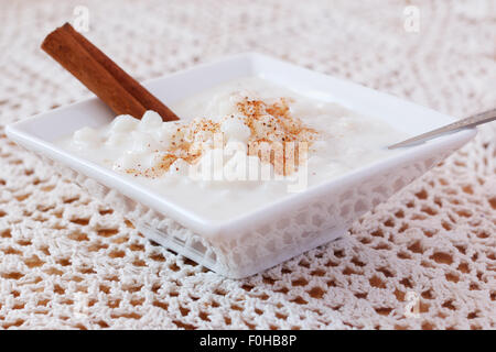 Brasiliano canjica dessert di mais bianco con cannella in piastra bianca su Centrino a crochet. Messa a fuoco selettiva Foto Stock