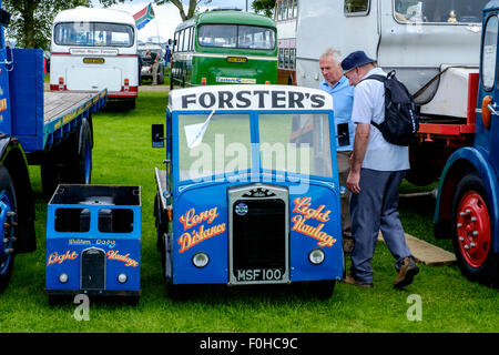 Due uomini ammirando gli automezzi pesanti in miniatura a Biggar Vintage Rally, South Lanarkshire, Scozia Foto Stock