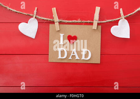 Padri messaggio della giornata con un feltro cuori appeso con clothespins rosso su tavola di legno Foto Stock