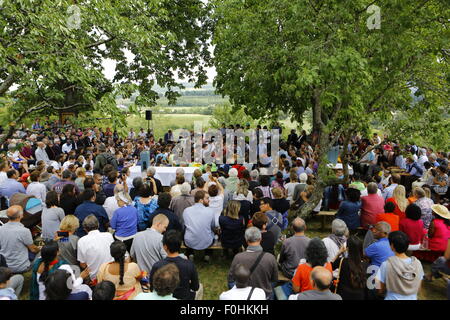 A Taizé, Francia. Il 16 agosto 2015. I leader della Chiesa e pellegrini di ascoltare il messaggio di saluto portato alla comunità di Taizé dai diversi dirigenti della Chiesa. I leader della Chiesa da diverse chiese cristiane come pure i rappresentanti delle religioni non cristiane hanno partecipato alla preghiera di rendimento di grazie in memoria di Frère Roger di Taizé in occasione del decimo anniversario della sua morte. Credito: Michael Debets/Alamy Live News Foto Stock