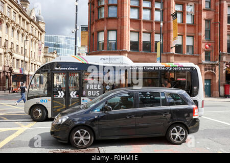 Bus navetta gratuito e auto nel traffico su Deansgate Manchester City Centre Inghilterra REGNO UNITO Foto Stock