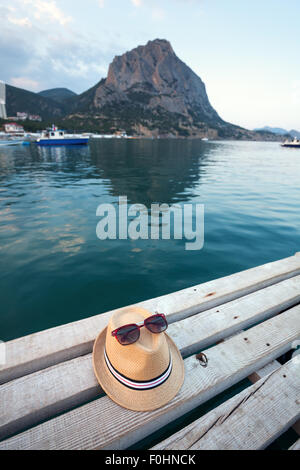 Occhiali da sole, flip-flop e hat sulla texture di legno in estate. Foto Stock