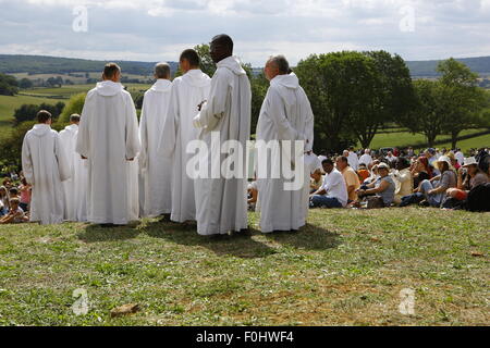 A Taizé, Francia. Il 16 agosto 2015. I fratelli di Taizé arrivare alla preghiera, indossando i loro tradizionali vesti bianche. I fratelli di Taizé, insieme a migliaia di pellegrini e i leader della Chiesa da molti diversi denominazione, terrà una preghiera di ringraziamento a Dio in memoria di Frère Roger in occasione del decimo anniversario della sua morte e nell'anno del suo centesimo compleanno e il settantacinquesimo anniversario del suo arrivo a Taizé. Foto Stock