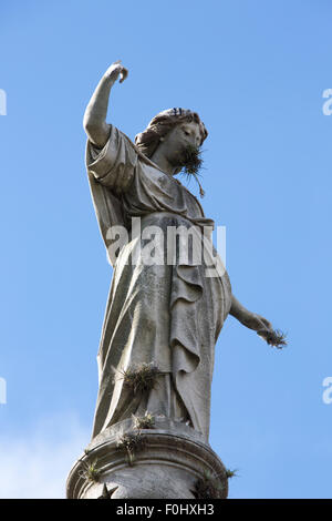 Statua e croce in La Recoleta Cemetery, un famoso cimitero situato nell'esclusivo quartiere di Recoleta di Buenos Aires Foto Stock